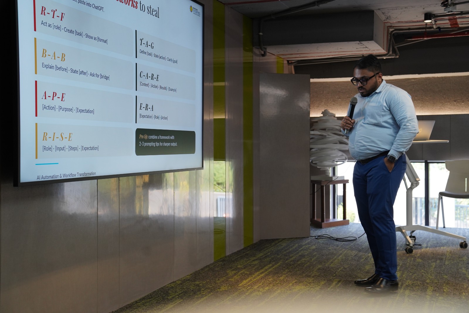 Sourish Mukherjee standing beside the full “Seven prompt frameworks to steal” slide, listing R-T-F, B-A-B, A-P-E, R-I-S-E, T-A-G, C-A-R-E and E-R-A.