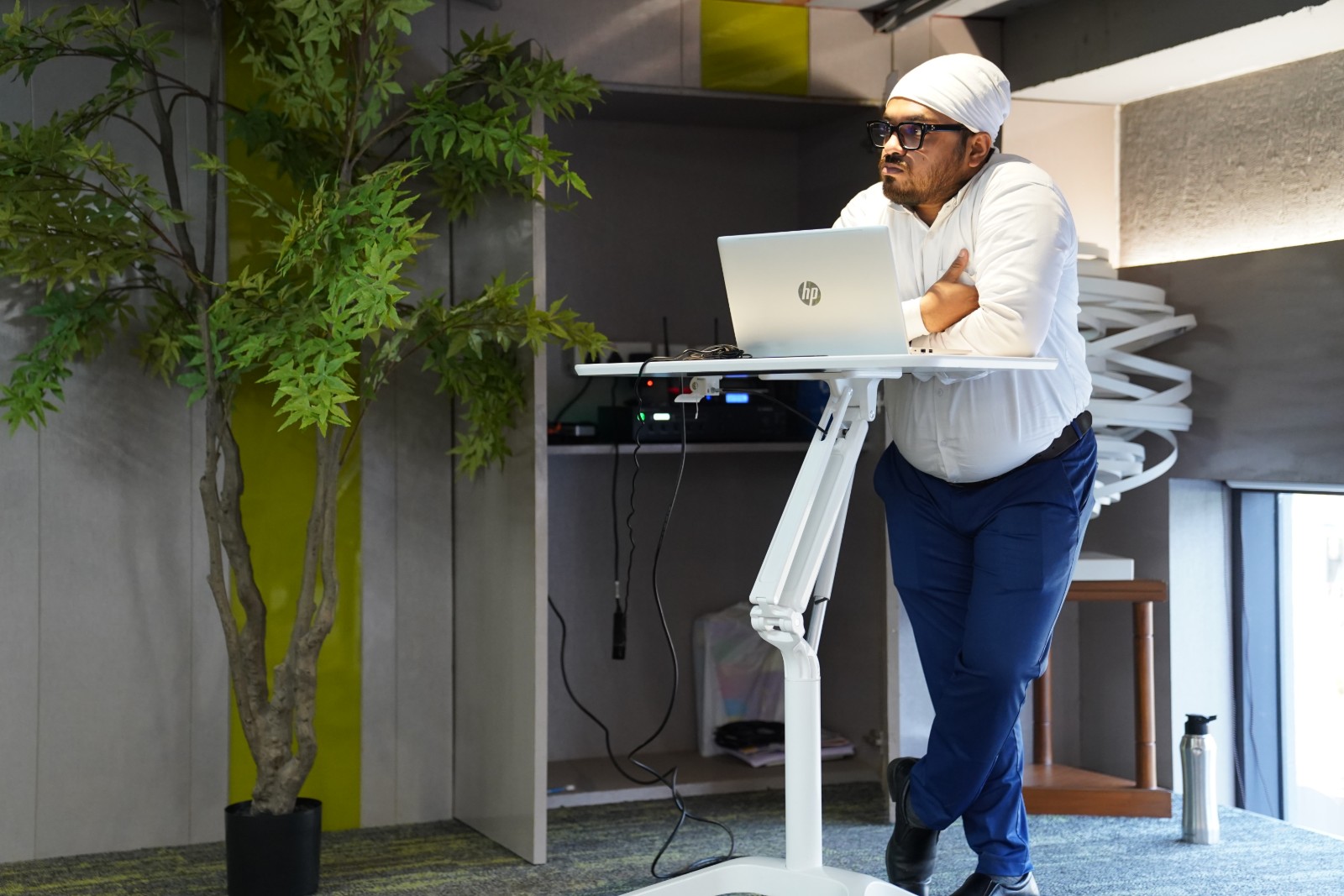 Sourish Mukherjee running the session from a standing desk, laptop open, between slides.